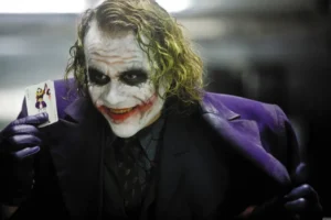 Man with joker makeup and card