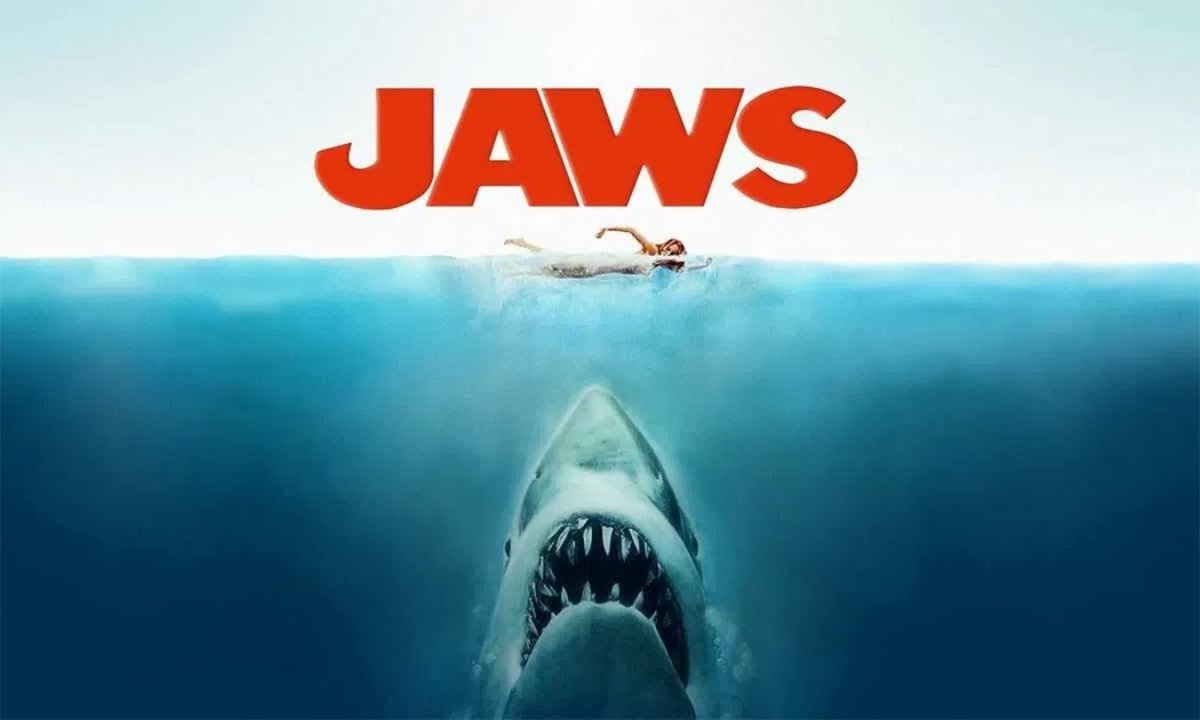 A swimmer is in dangerous waters as a massive shark with sharp teeth emerges below, set against the 