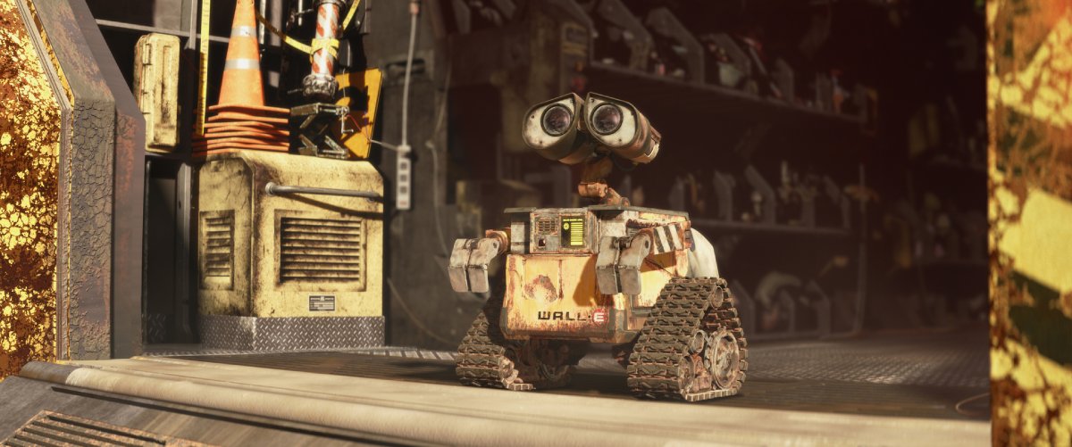 A rusty robot named WALL-E stands on a gritty metallic surface, surrounded by industrial debris and worn-out equipment in a cluttered environment.