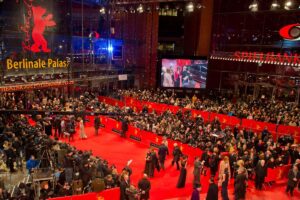 The bustling red carpet at the Berlinale Palast, filled with celebrities, photographers, and fans during the Berlin International Film Festival.